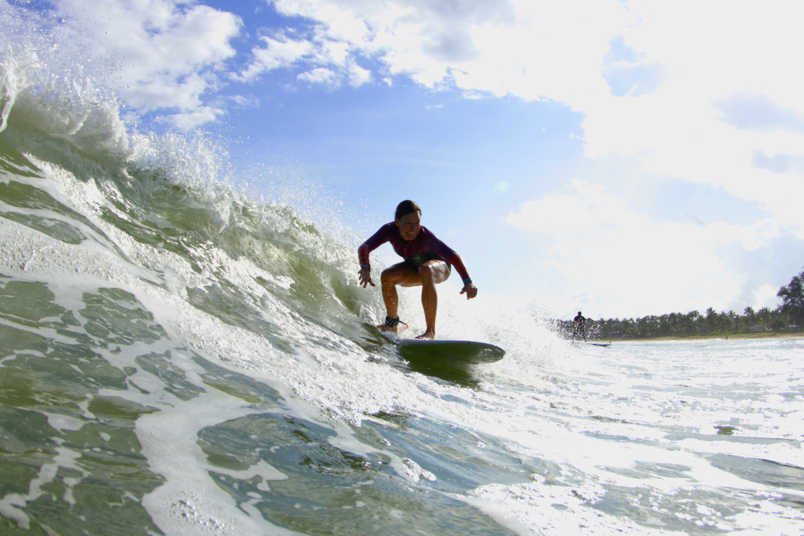 Noelle Salmi rides a wave in Hanalei Bay - Kauia, HI. Photograph by Ry Cowan.